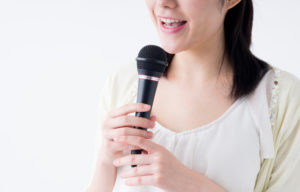 マイクを持って歌う